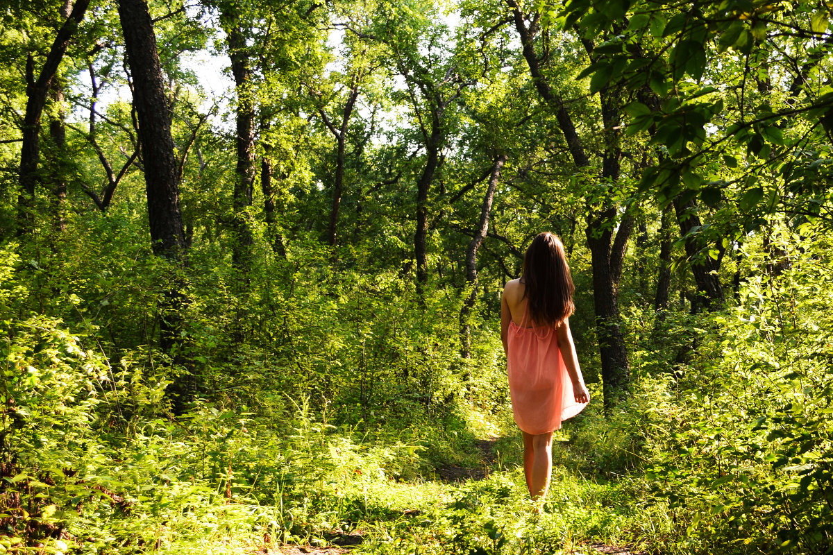 Девушка с большими дойкамигуляет по лесу