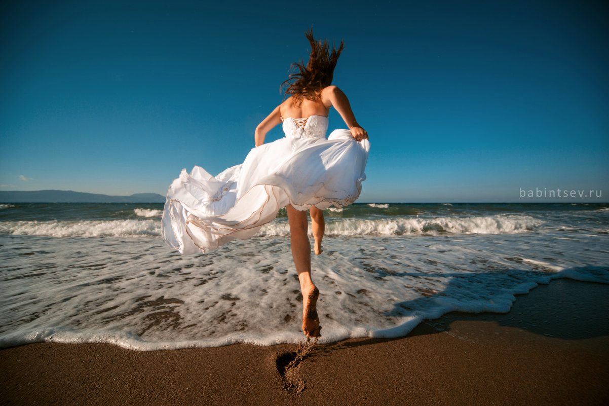 Девушка бежит в море