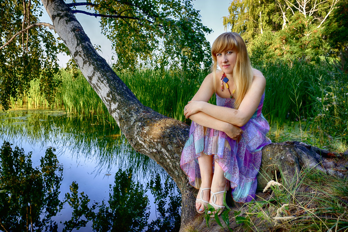 Деревенская девушка позирует на речке перед камерой
