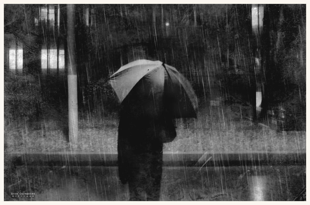 Человек с зонтом под дождем
