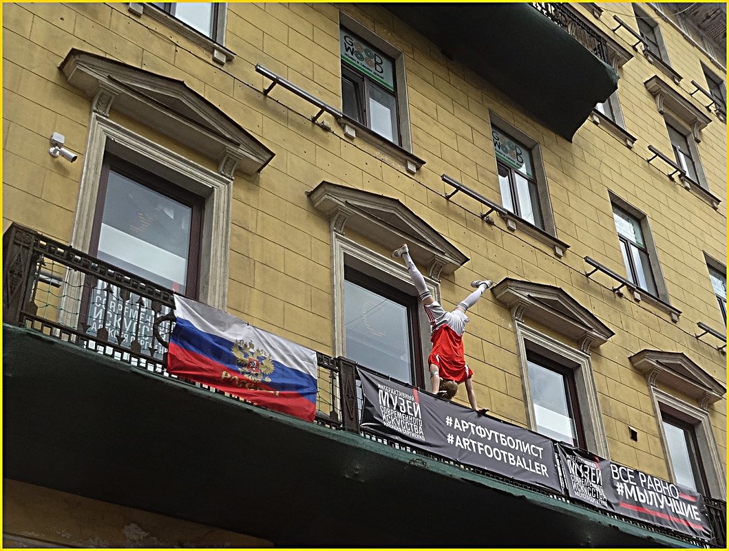 На балконе на Невском в стойке на руках завис футболист - Вера 