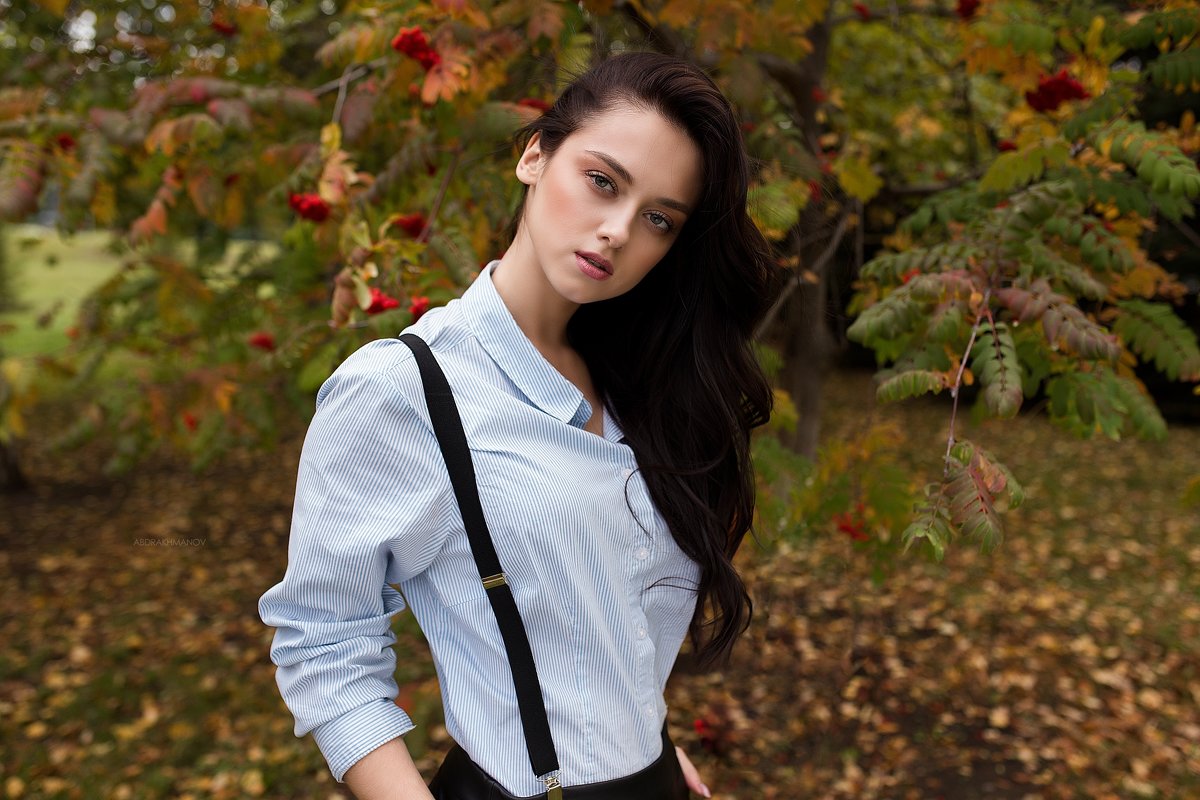 Фотография на тему Красивая девушка в белой рубашке и черных брюках на подтяжках | PressFoto
