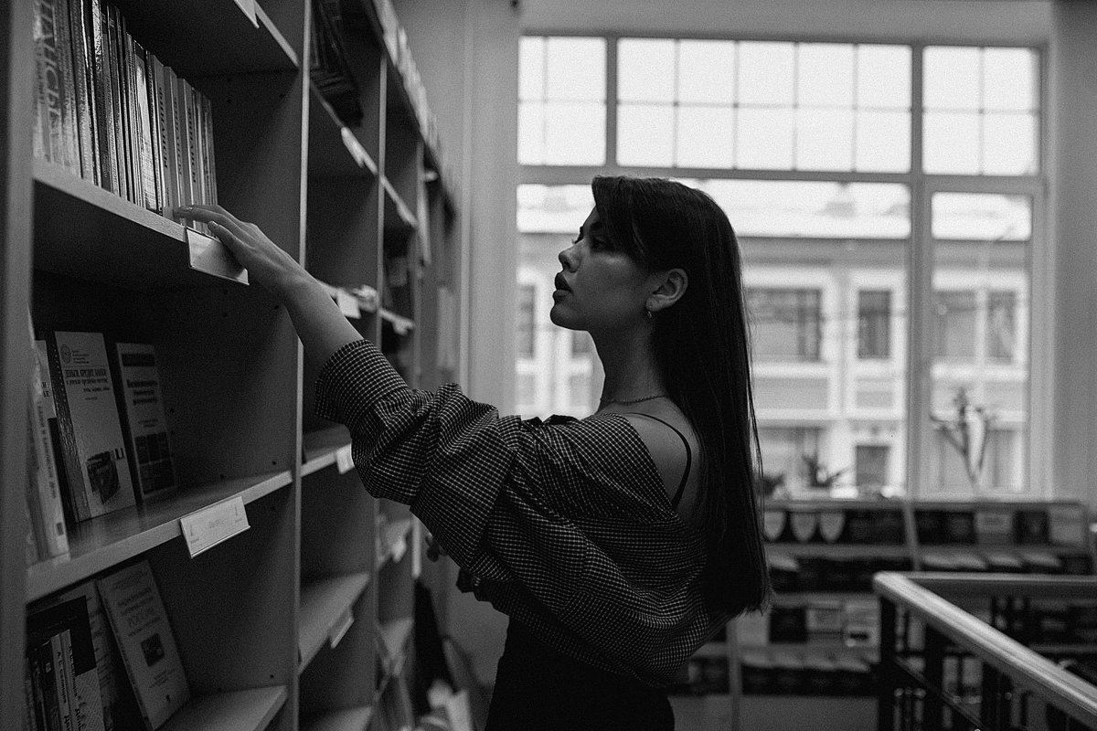 Красивая девушка в библиотеке в поисках книги - Lenar Abdrakhmanov