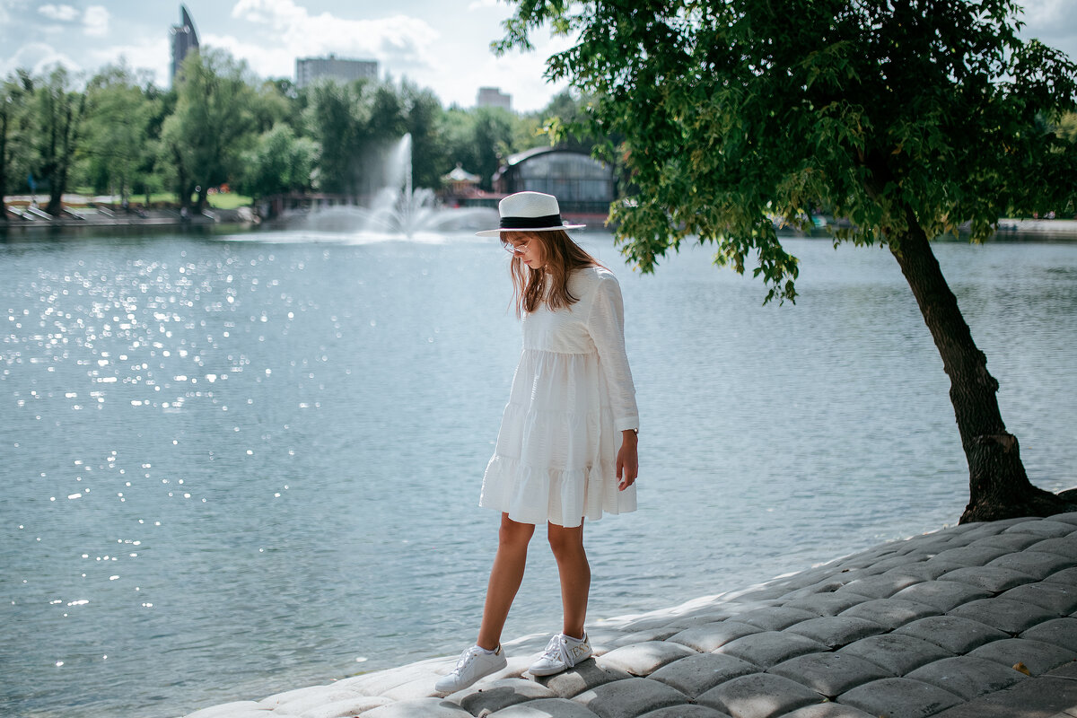 Девушка в белом платье и белой шляпе гуляет по берегу парка - Lenar Abdrakhmanov