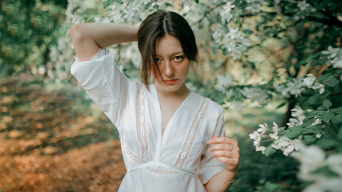 Девушка в легком белом полупрозрачном платье гуляет по цветущему весеннему саду - Lenar Abdrakhmanov