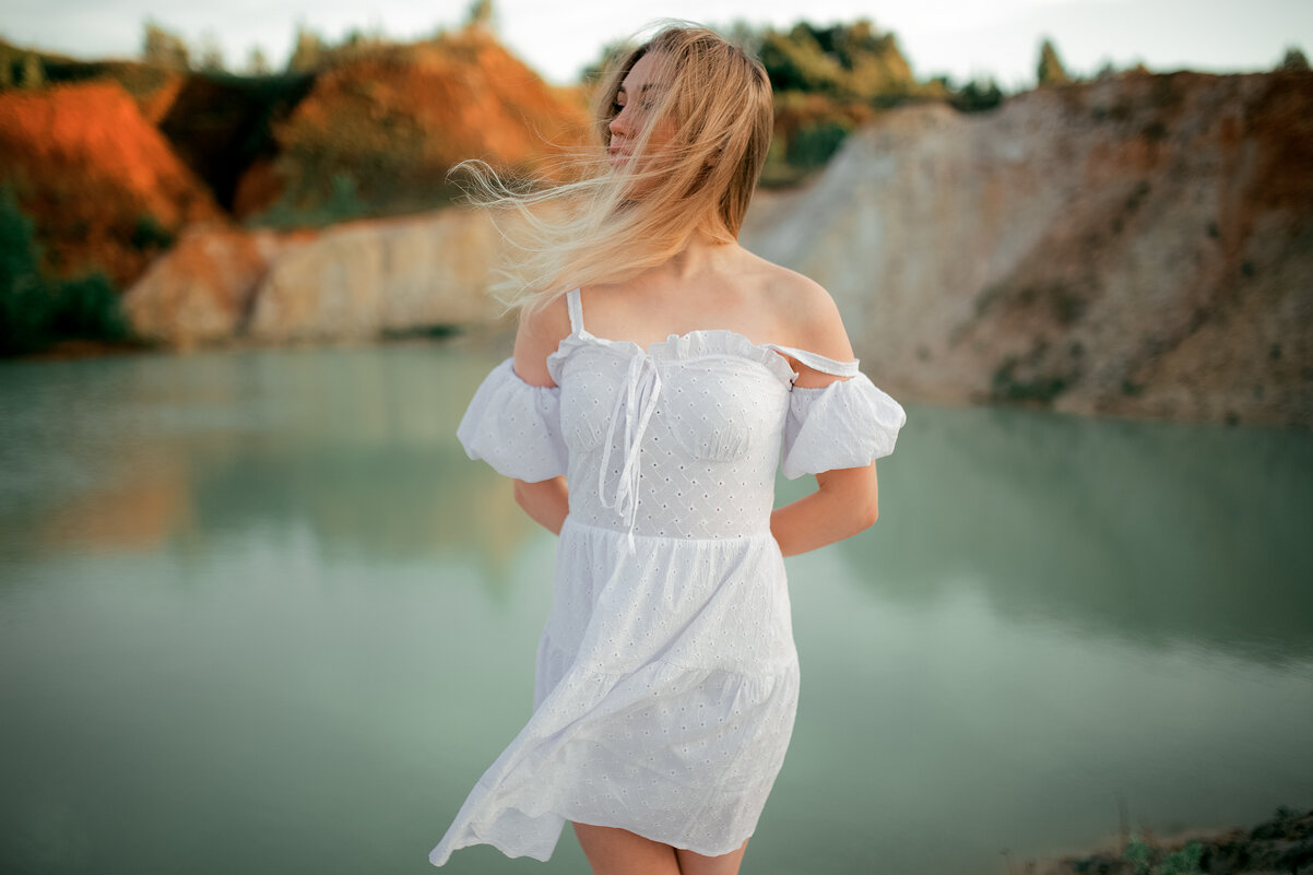 Девушка в легком белом платье гуляет по берегу песчаного карьера на рассвете - Lenar Abdrakhmanov