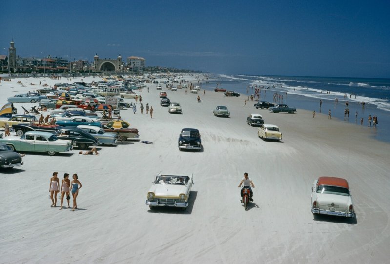 Автомобили, мотоциклы и любители позагорать на пляже в Дейтона-Бич, штат Флорида.