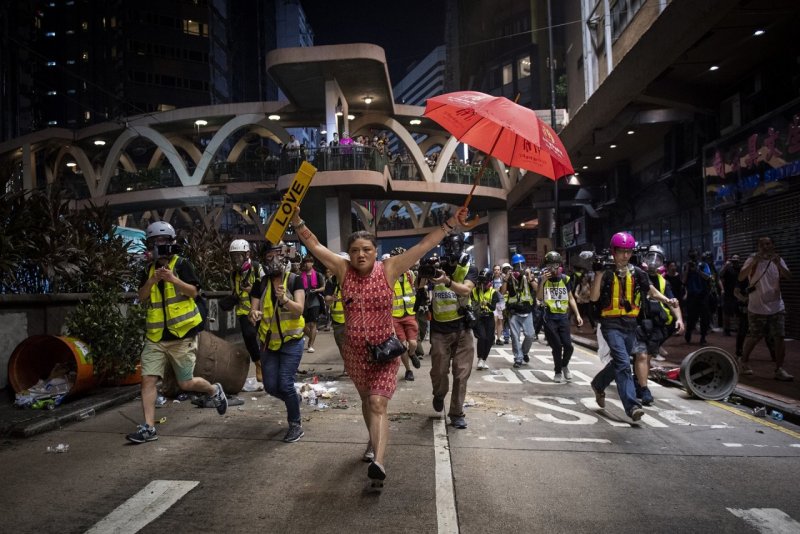 Женщина с зонтиком (символ протеста) во время демонстраций в Гонконге против законопроекта об экстрадиции, 1 октября 2019. Автор Николас Асфури.