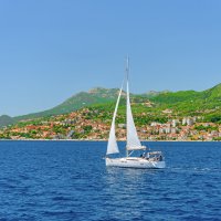 Белоснежная яхта в Которском заливе напротив Херцег-Нови, Черногория